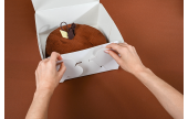 Der Kuchenkarton mit anhängendem Deckel ist einfach aufzurichten.
