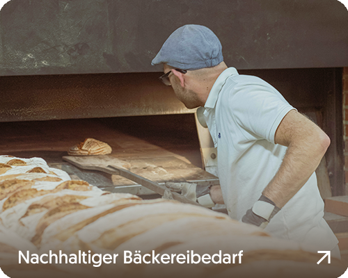 Bäcker der ein Brot in den Ofen schiebt